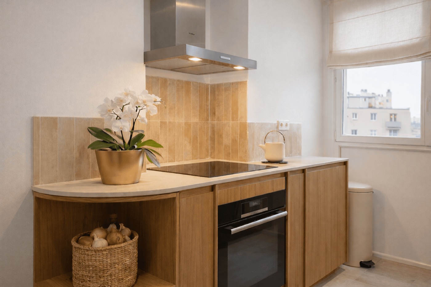 Oak kitchen with a pale stone worktop and glazed terracotta tiling, in an apartment renovated in the 7th arrondissement of Marseille